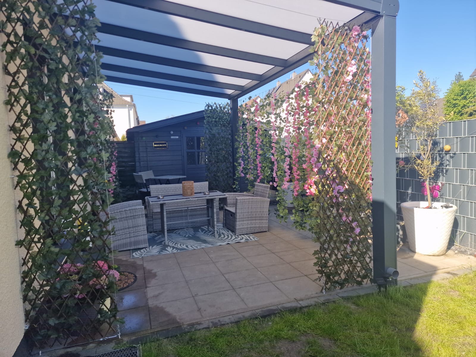 Überdachte Terrasse mit gemütlicher Sitzgruppe